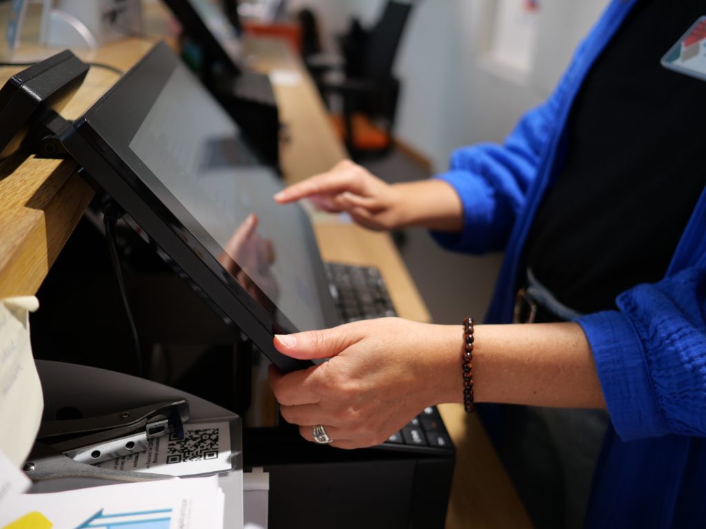 Une médiatrice en train de taper sur l’écran de la caisse du musée.