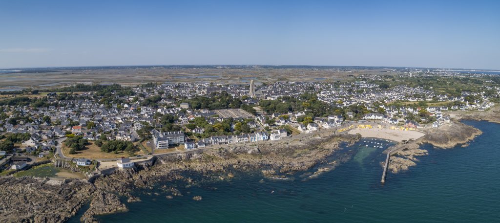Photo prise par drone montrant la plage Saint-Michel à Batz-sur-Mer, avec le sable clair, l’eau calme et quelques promeneurs.